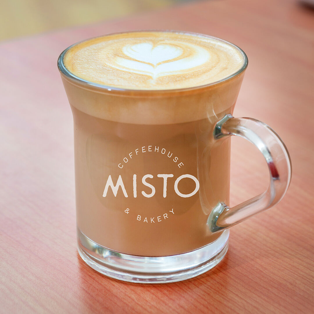 A glass Misto mug of latte with heart latte art.